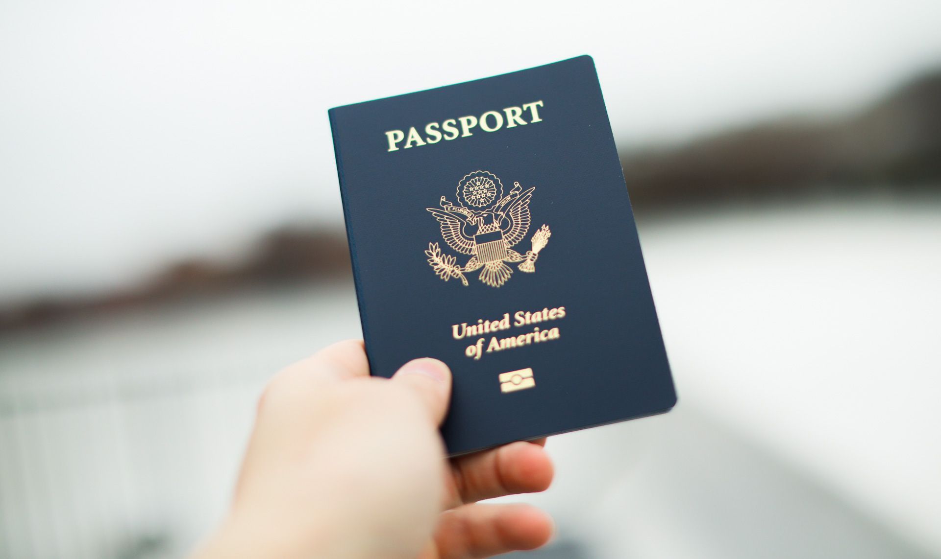 A person is holding a passport in their hand.