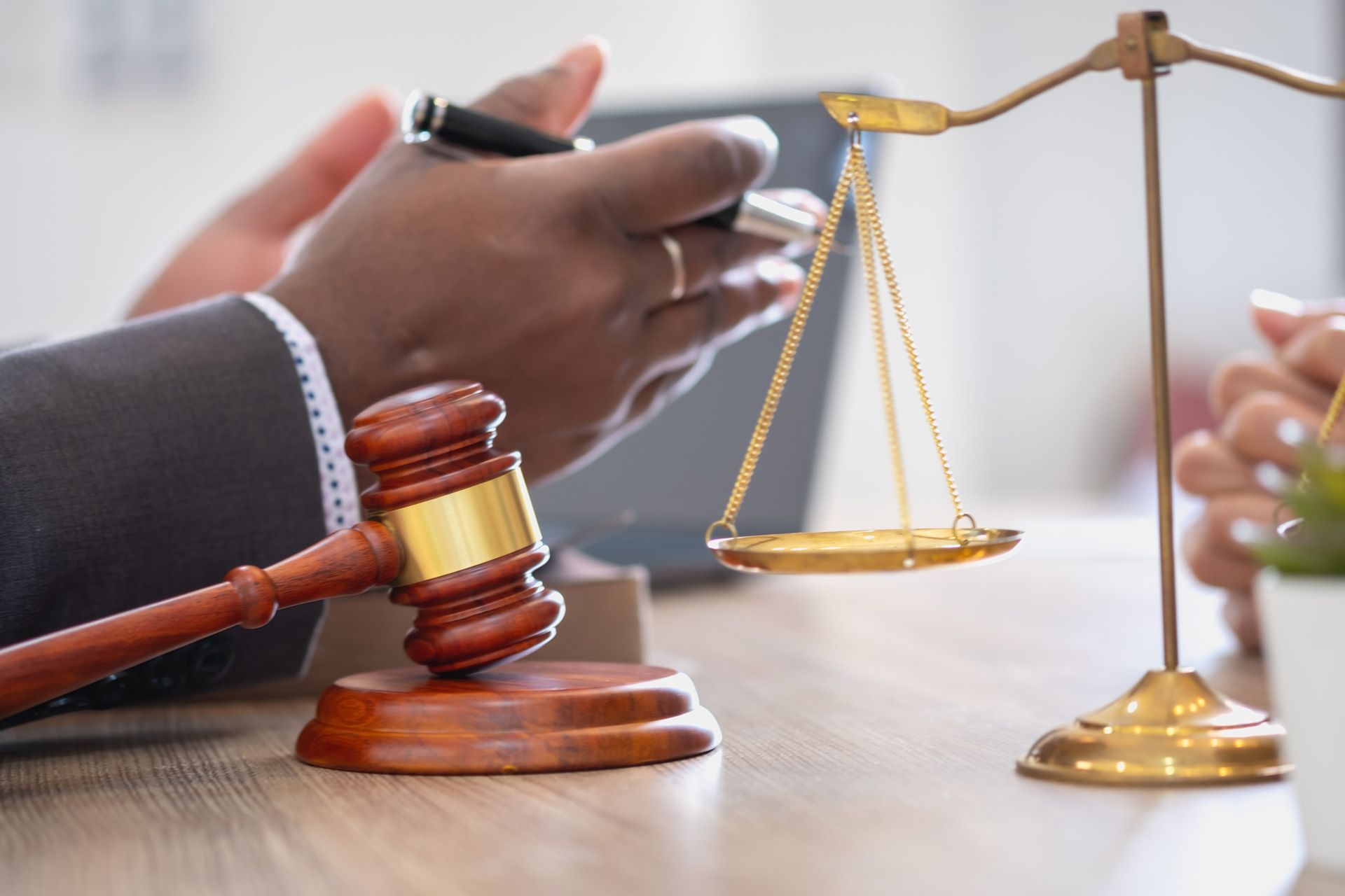 A judge is sitting at a table with a gavel and scales of justice.