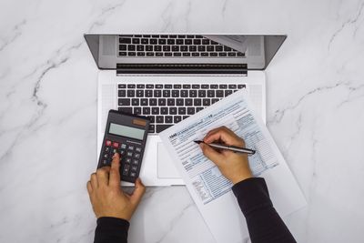 Laptop with Document and Calculator — Savannah, GA — Bailey Capital Solutions