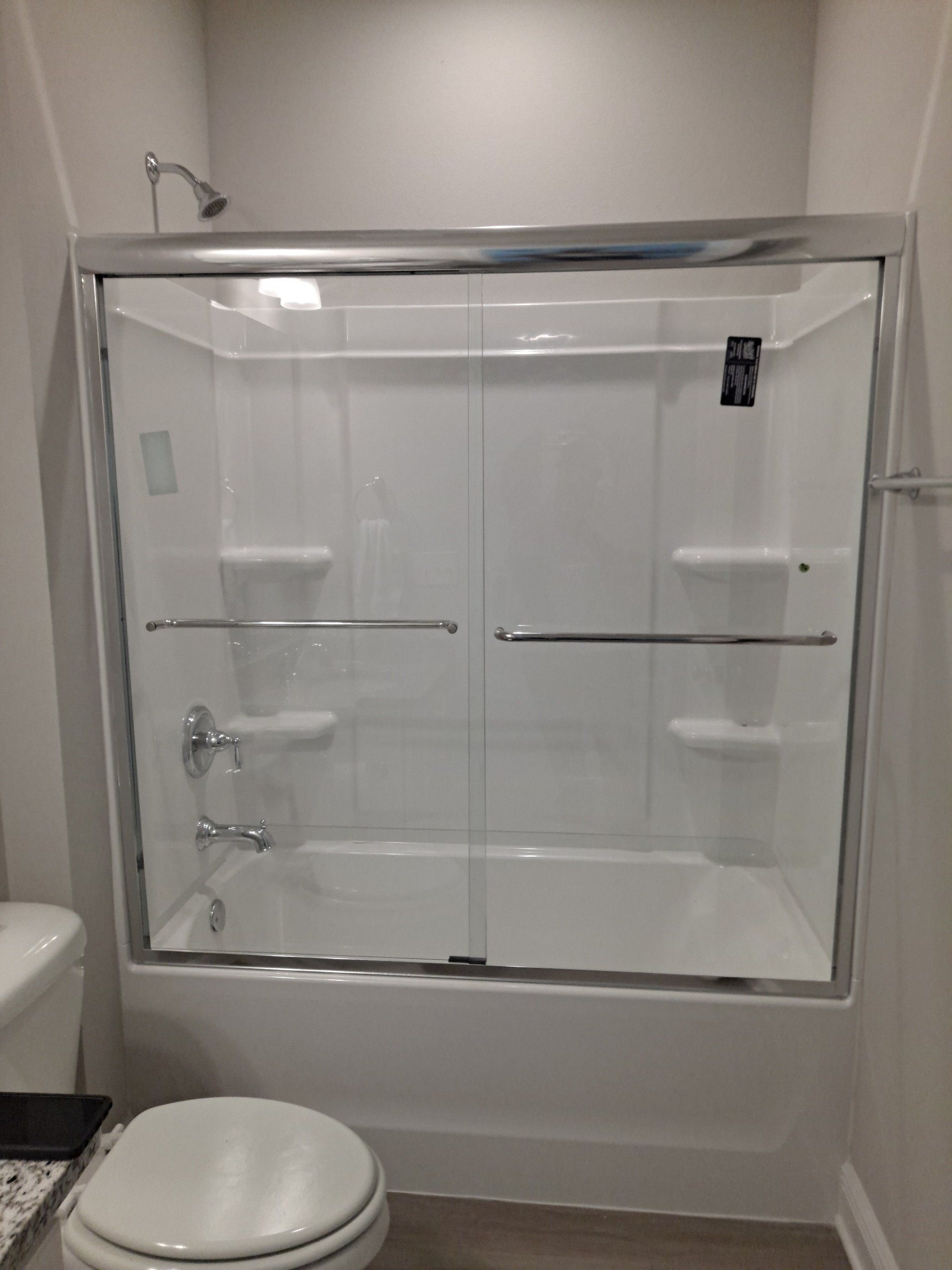 fiberglass shower enclosure with sliding glass doors and chrome hardware