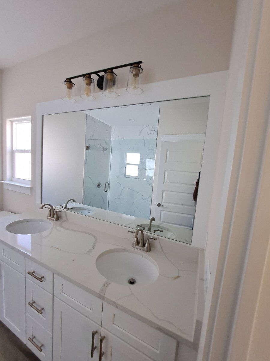 double vanity with marble countertops and large mirror above