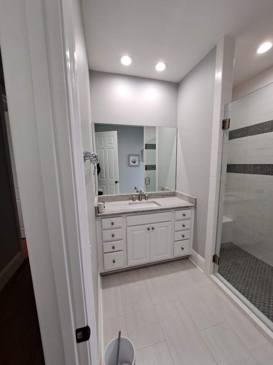 white bathroom vanity with mirror and glass door