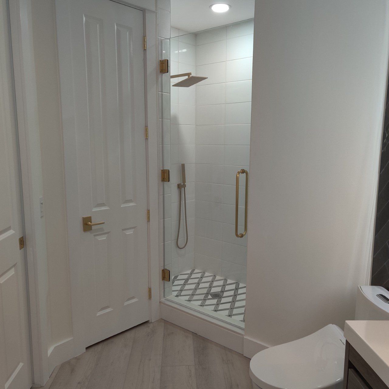 white tile and gold hardware with glass