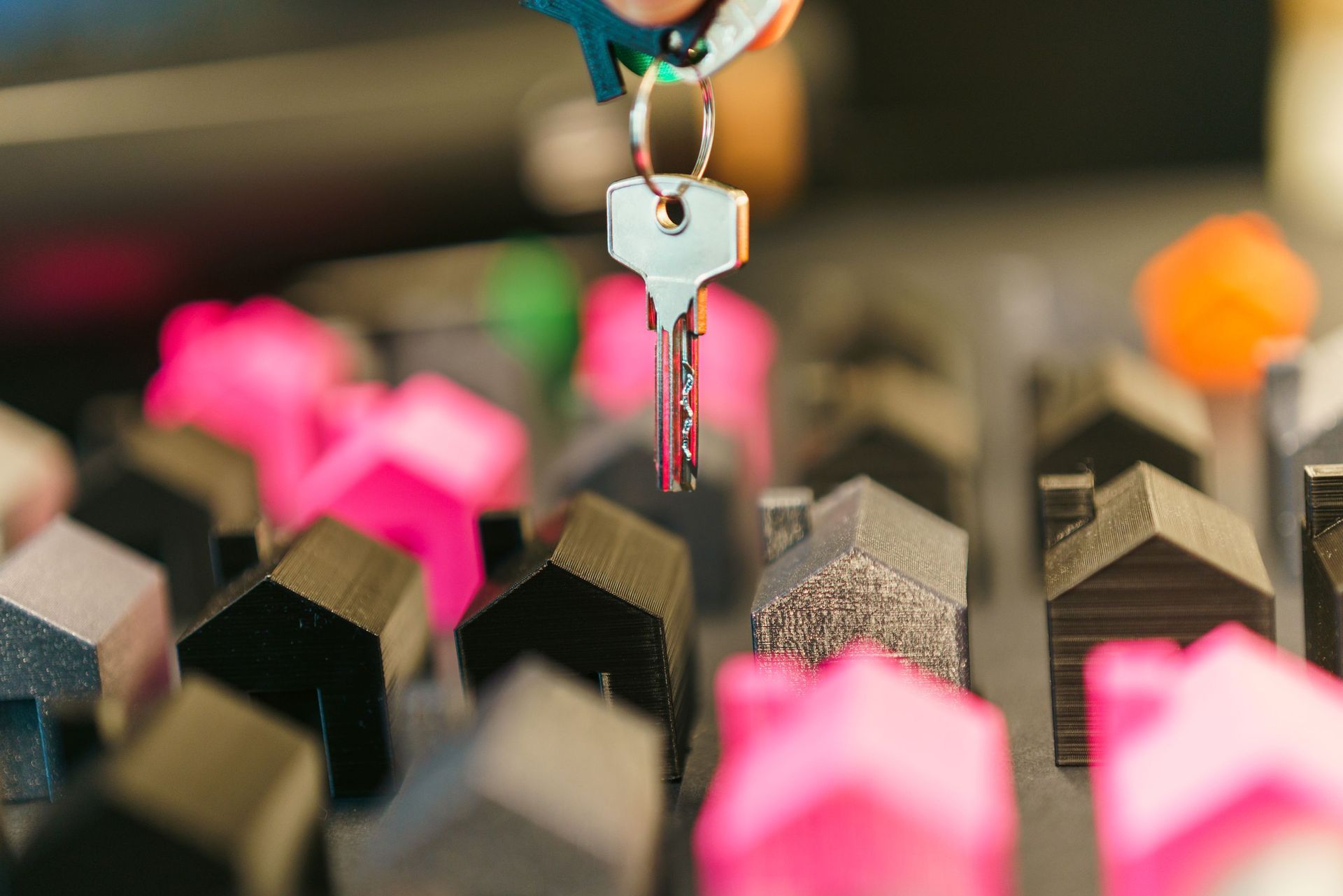 Close-up of a key inserted into a lock among rows of blurred pink and black keys