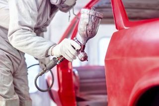 Auto bodywork and painting - MProfessional worker spraying red paint on a car body in Mesa, Arizona