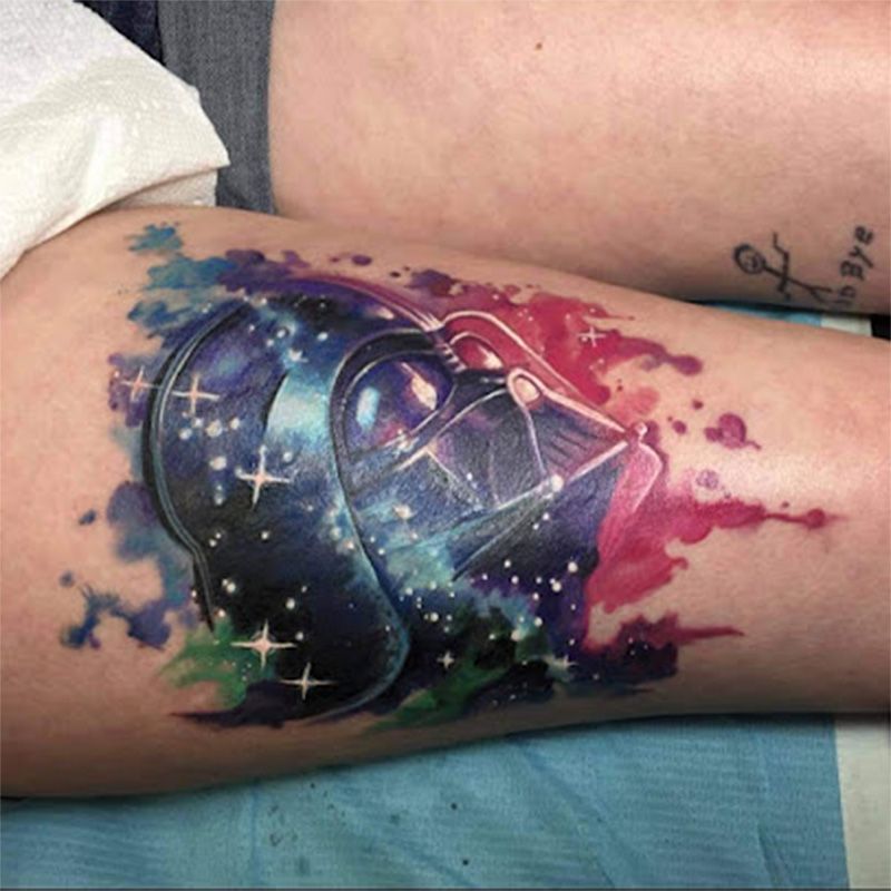 A person has a tattoo of darth vader on their leg.