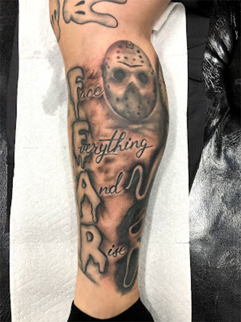 A person has a tattoo of jason voorhees on their leg.
