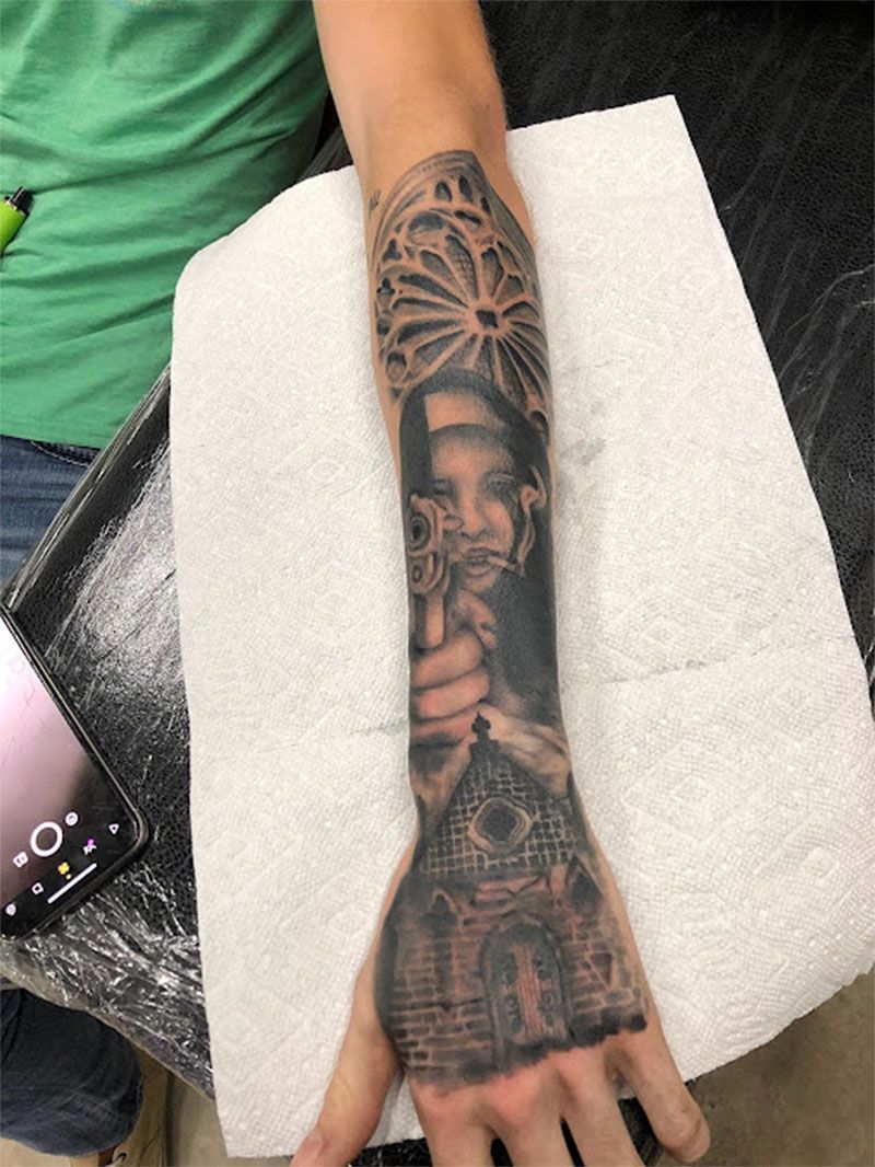 A person with a tattoo on their arm is holding a paper towel.