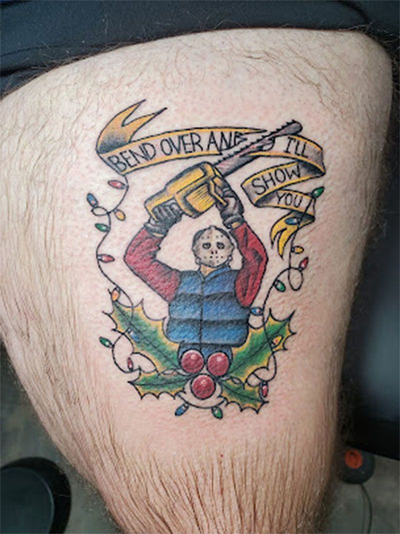 A person has a tattoo of jason voorhees holding a chainsaw on their leg.
