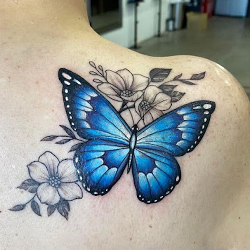 A woman has a blue butterfly tattoo on her back.