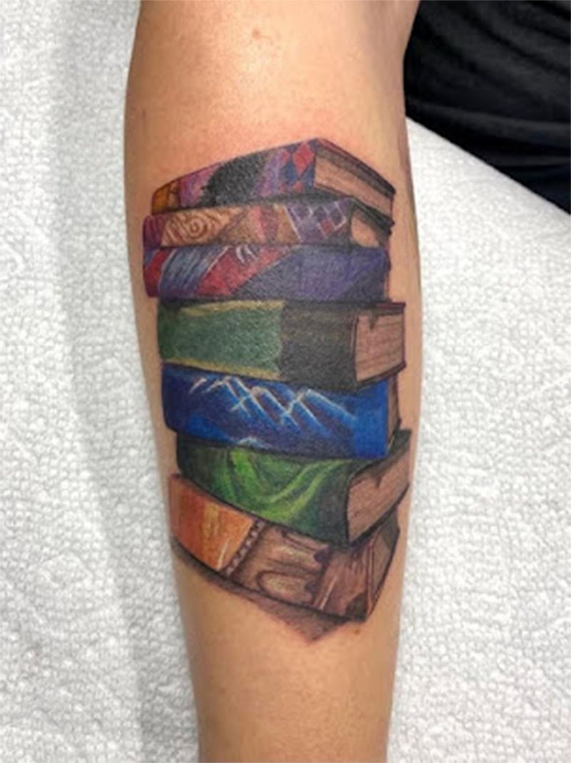 A tattoo of a stack of books on a person 's leg.