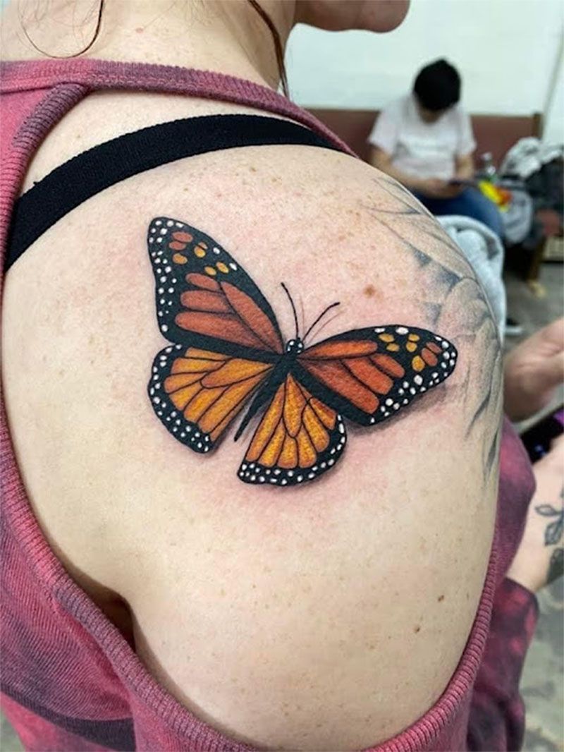 A woman has a butterfly tattoo on her shoulder