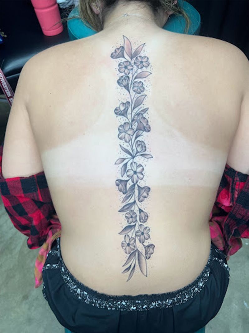 A woman has a tattoo of flowers on her back