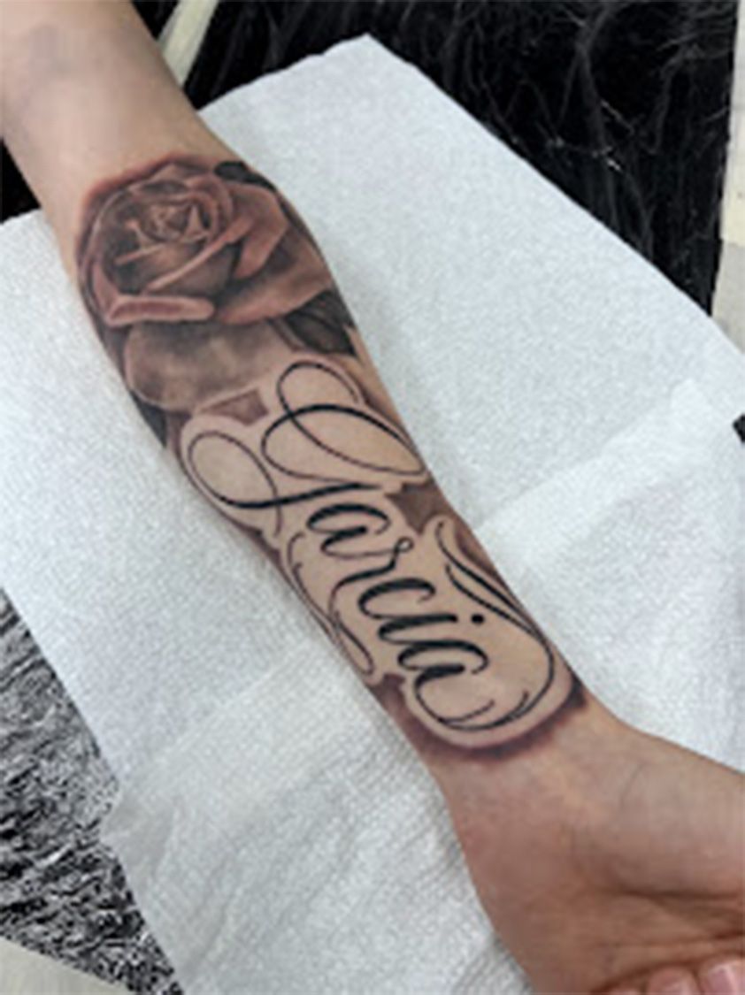 A person has a tattoo on their arm that says loria