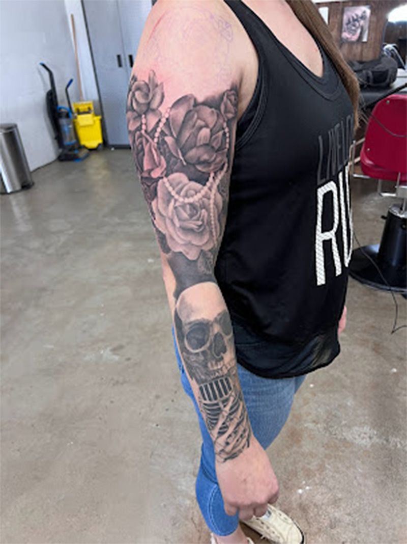 A woman with a skull and roses tattoo on her arm.