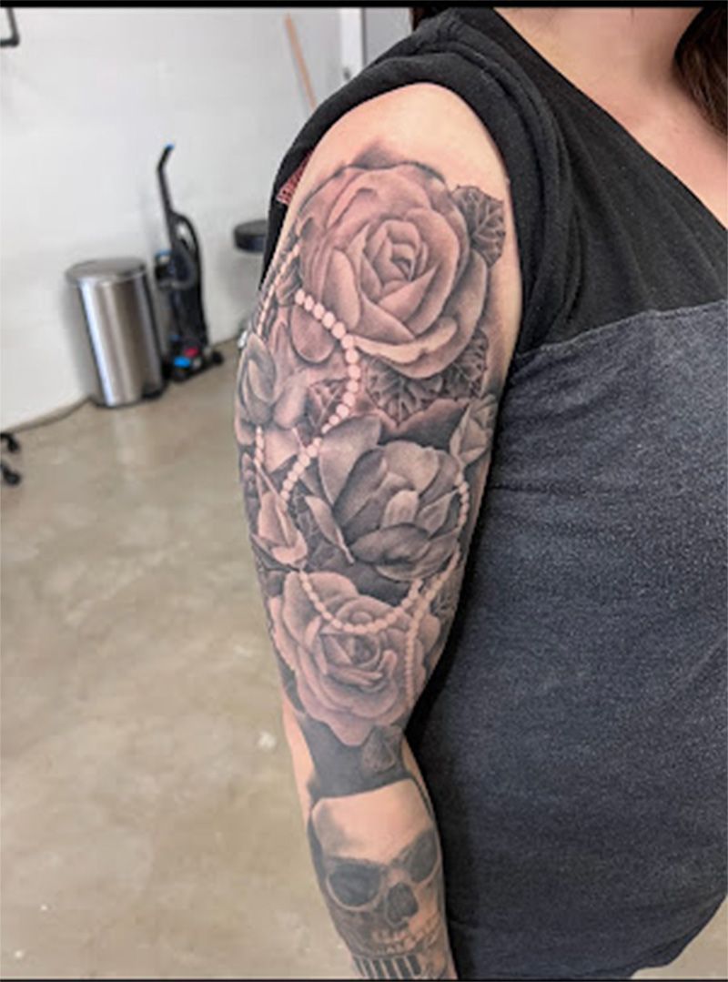 A woman has a tattoo of roses and skulls on her arm.