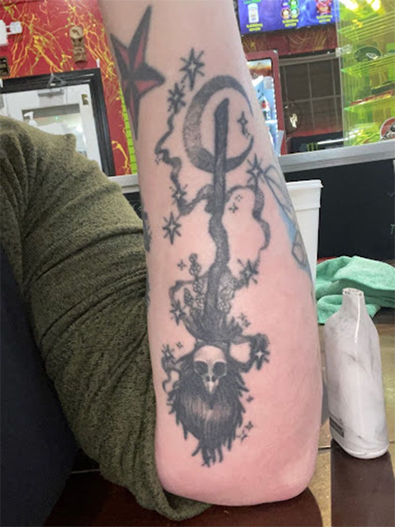 A person has a tattoo on their arm that looks like a lizard