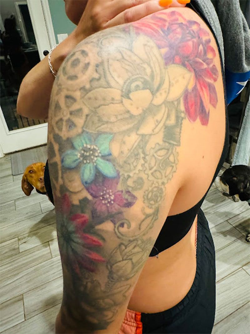 A woman has a tattoo of flowers on her shoulder
