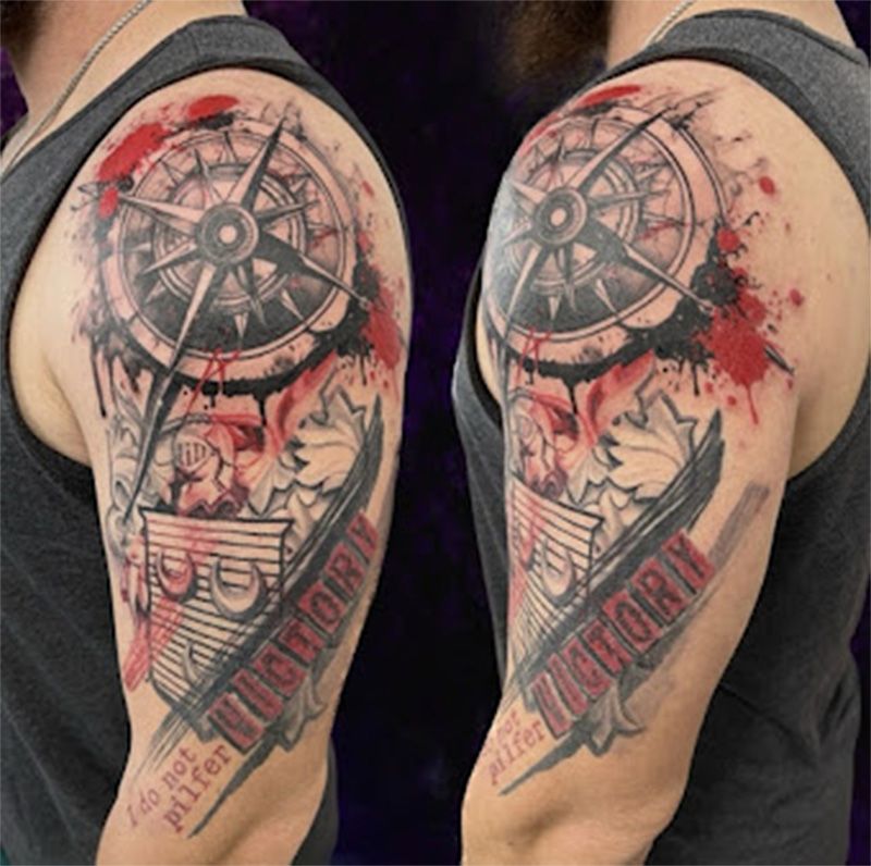A man has a tattoo of a compass on his arm