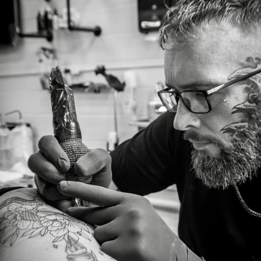 A woman has a tattoo of a skull and butterflies on her arm.