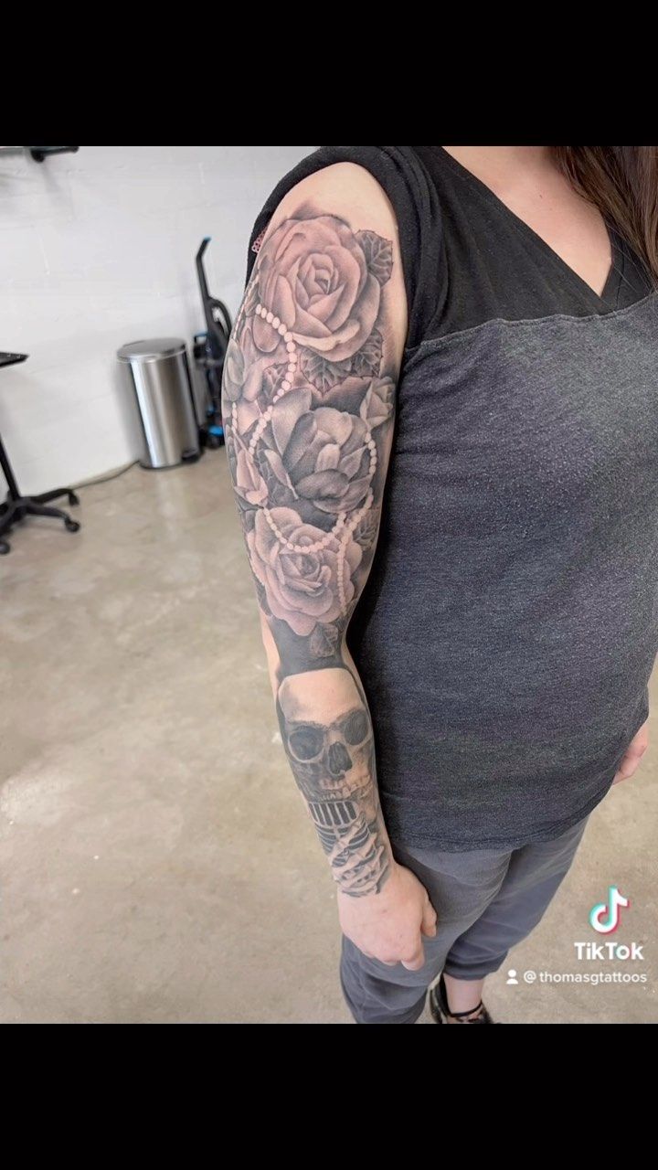 A woman with a tattoo on her arm is standing in a room.