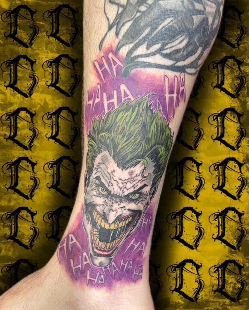A person has a tattoo of the joker on their leg