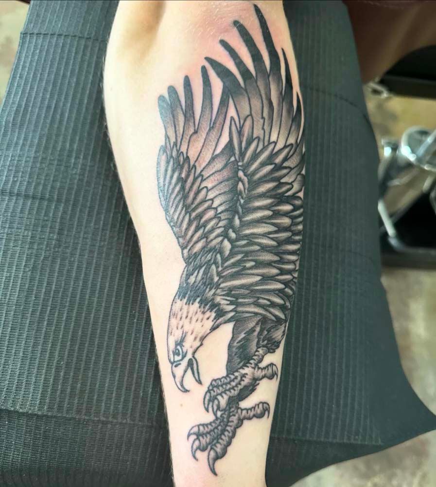 A person has a tattoo of an eagle on their arm