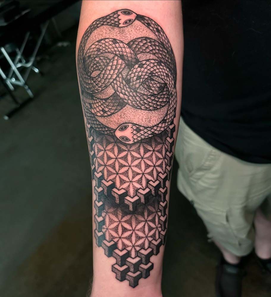 A man has a tattoo of a snake on his forearm