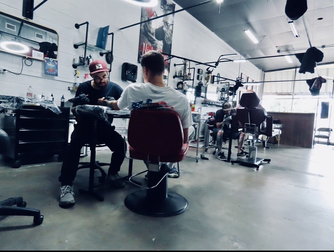 A man is sitting in a chair in a barber shop