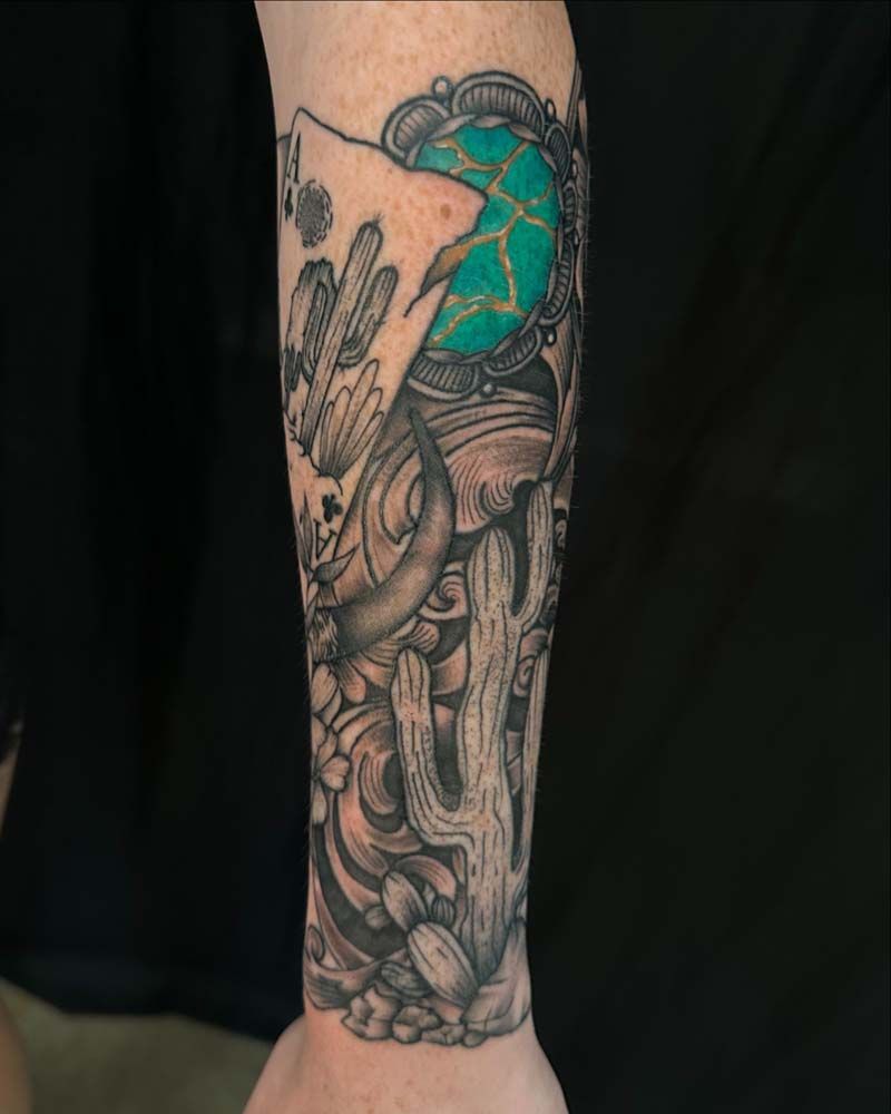 A person has a tattoo of a cactus and a globe on their forearm.