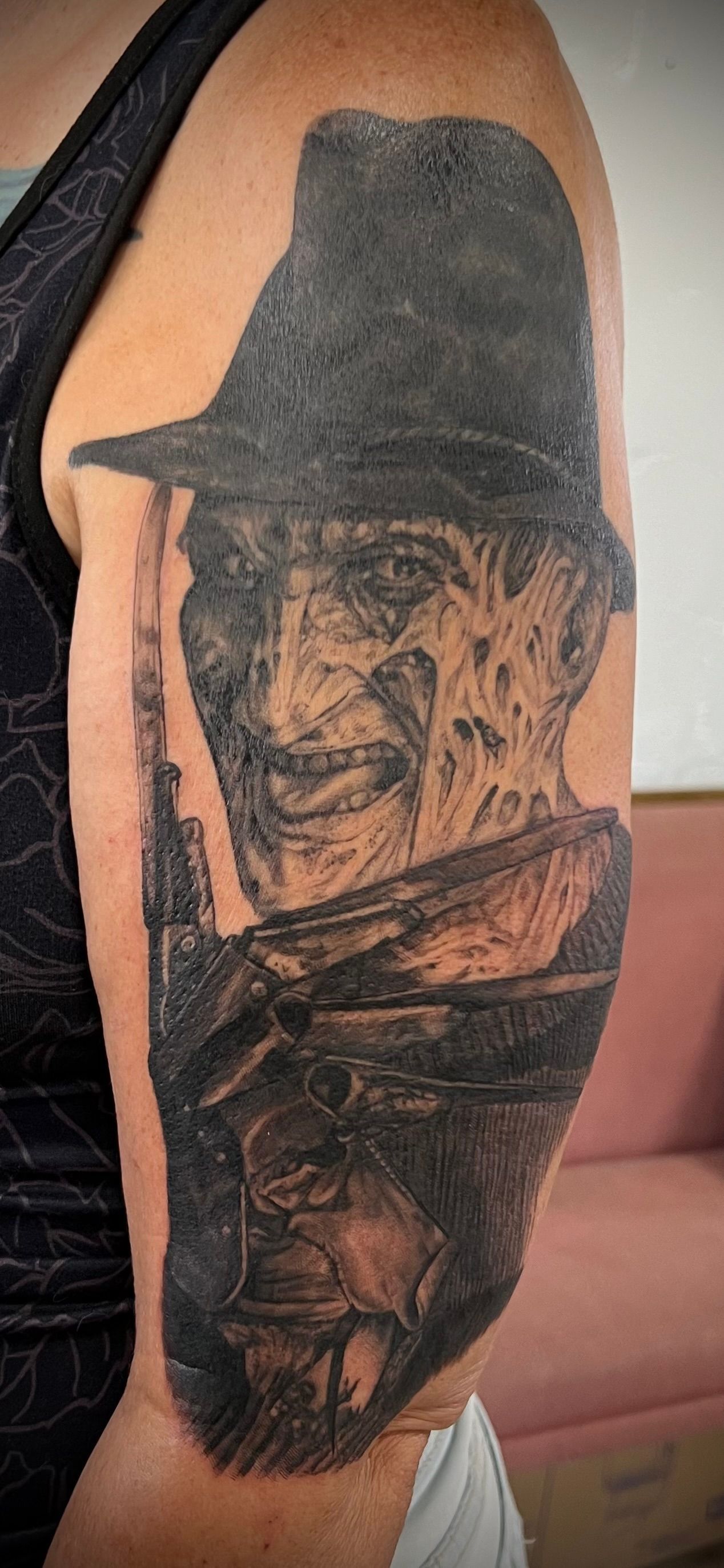 Tattoo of Freddy Krueger on a person's arm. The image is black and gray.