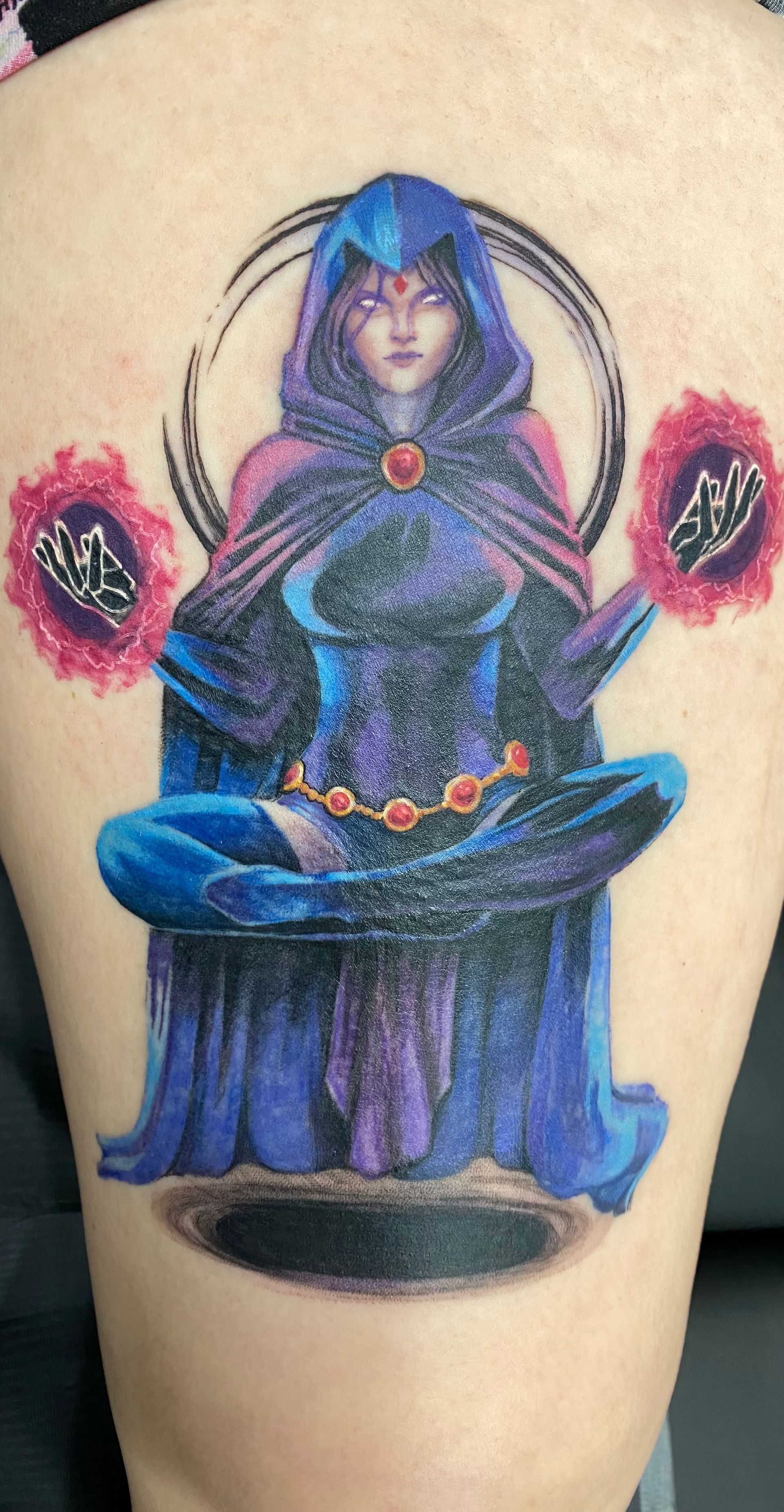 Tattoo of Raven meditating, with a black portal and two glowing orbs, on a leg. Purple, blue, and black colors.