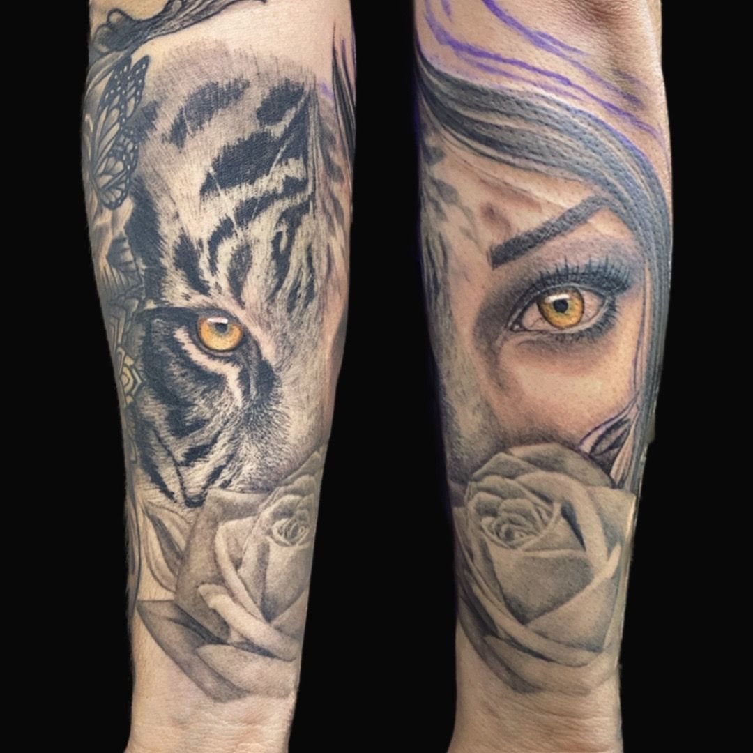 Tattoos: tiger face and woman's eye, both with yellow eyes, overlaid on roses, on a person's arm.