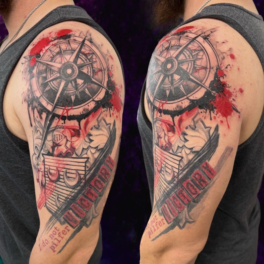 Tattoo on a man's arm: compass, red watercolor splatters,