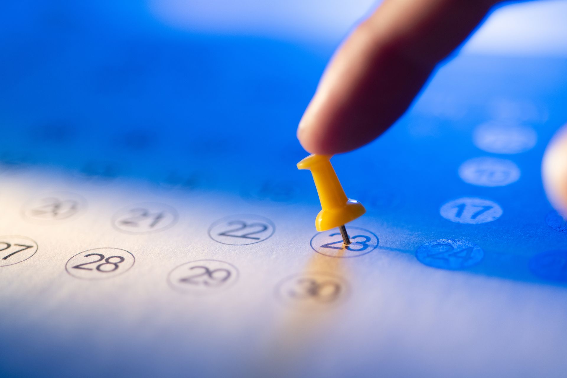 Human hand pusing pin on calendar representing annual furnace maintenance in Houston area home.