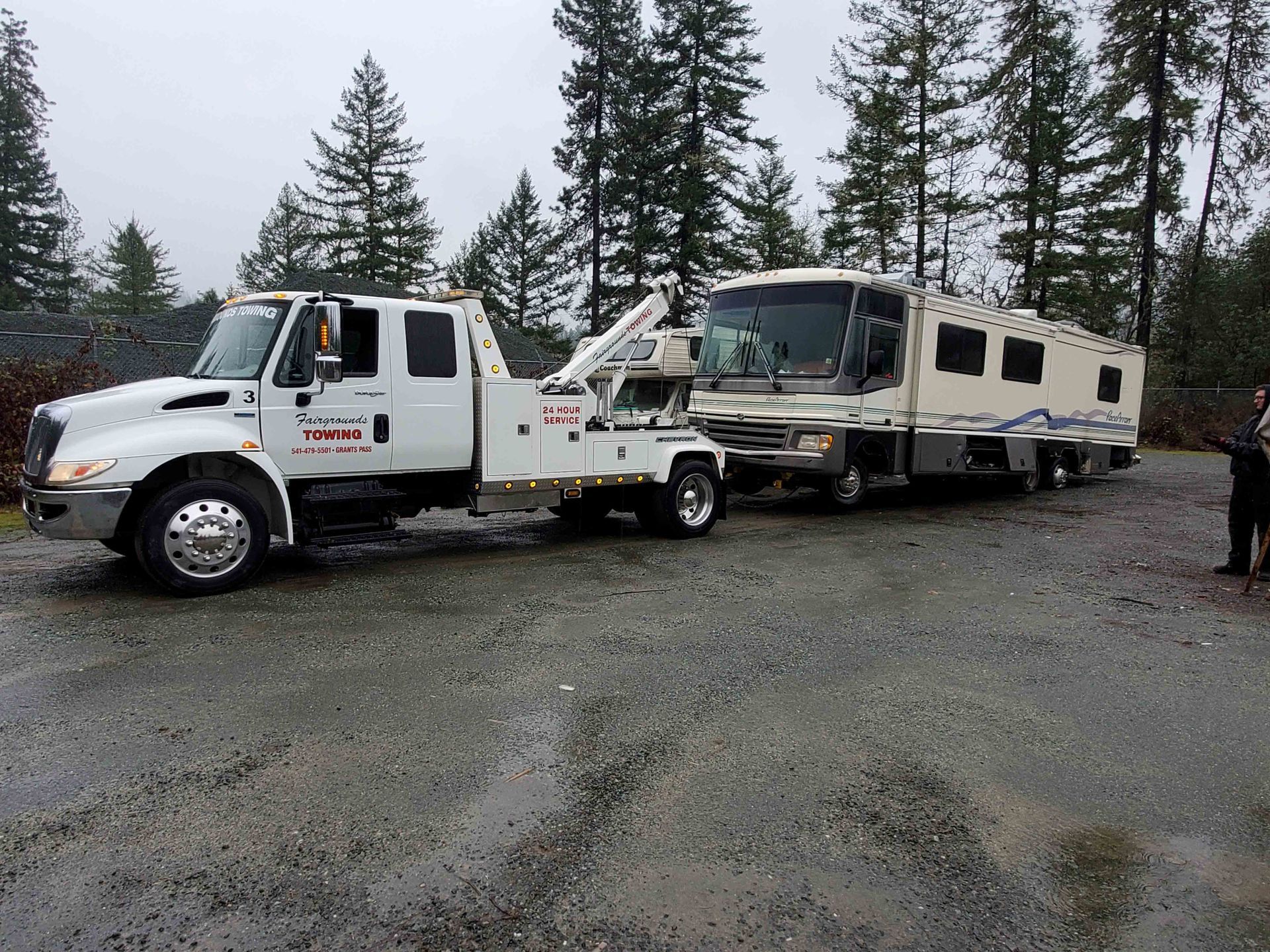 A White Tow Truck Is Towing A RV — Grants Pass, OR — Fairgrounds Towing & Fuel LLC