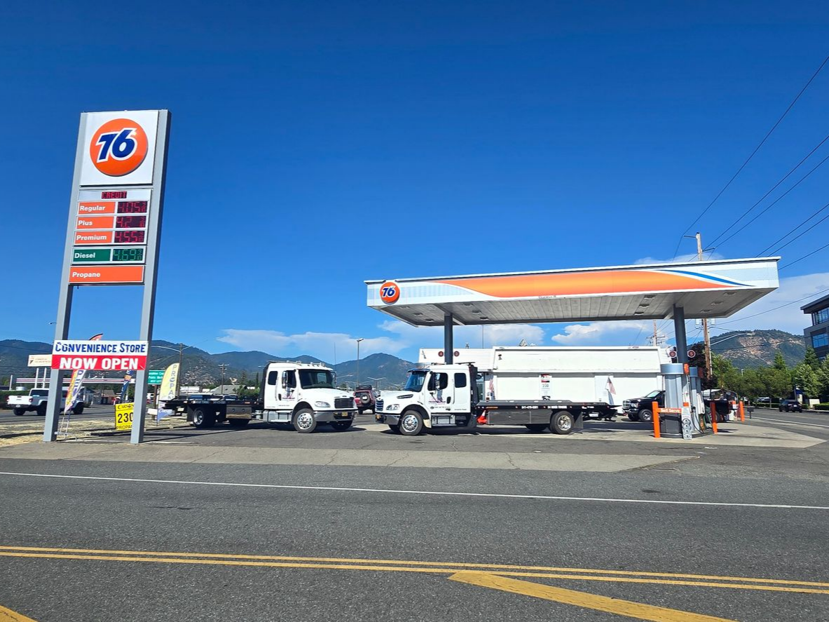 A Man Kneeling Next To Two Dogs In Front Of A Tow Truck — Grants Pass, OR — Fairgrounds Towing & Fuel LLC A Man Kneeling Next To Two Dogs In Front Of A Tow Truck — Grants Pass, OR — Fairgrounds Towing & Fuel LLC