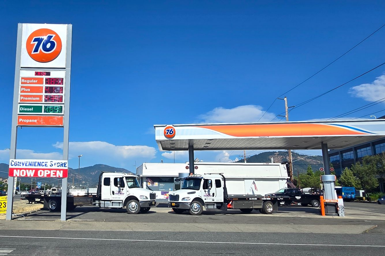 Modern roadside gas station services with red canopy and fuel pumps under blue sky. Modern roadside gas station services with red canopy and fuel pumps under blue sky.
