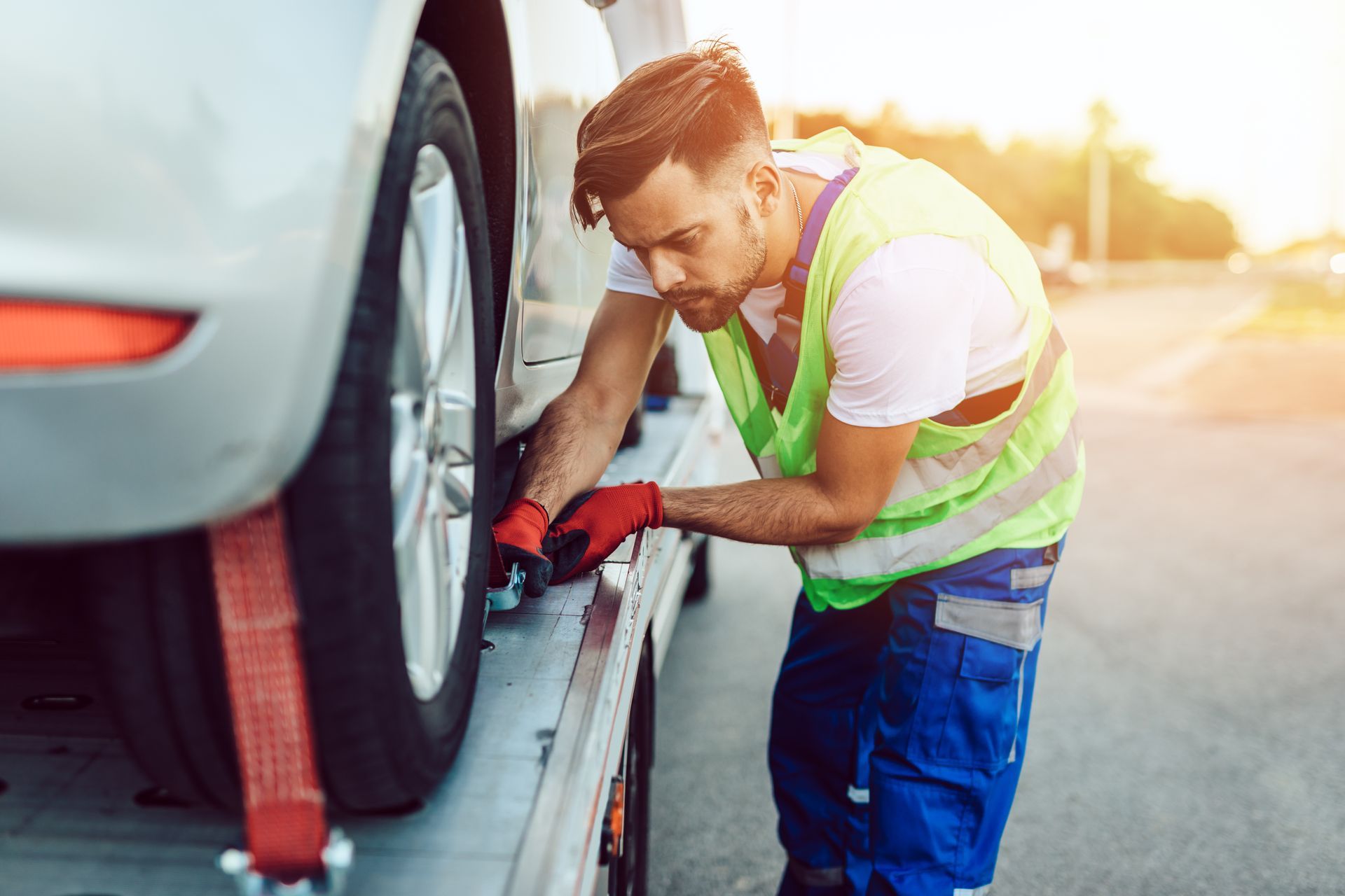 A man working on a towing service on a road. A man working on a towing service on a road.