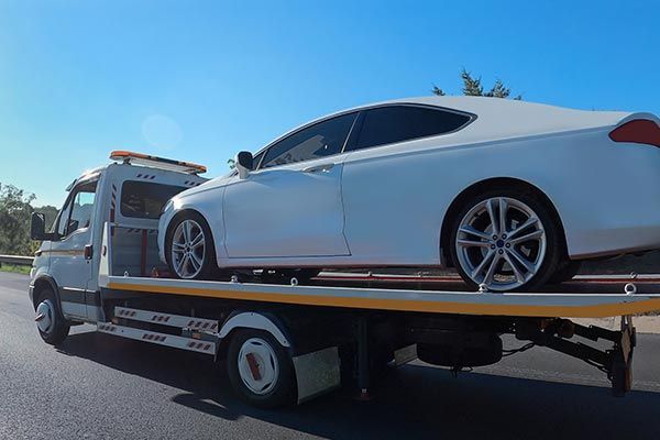 A White Car Is Being Towed — Grants Pass, OR — Fairgrounds Towing & Fuel LLC