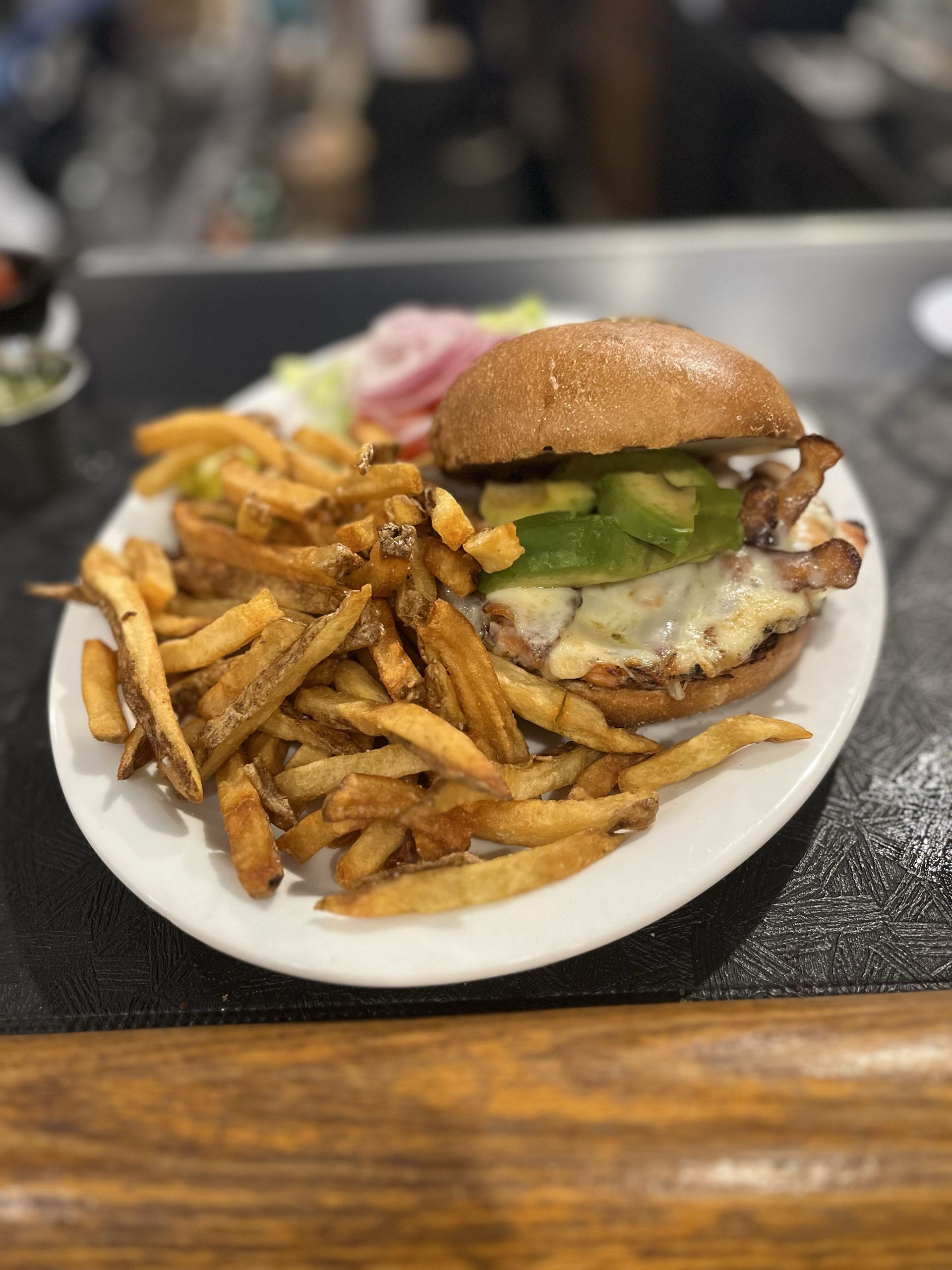 Chicken Caesar salad on a wooden board with lettuce, chicken, and parmesan cheese.