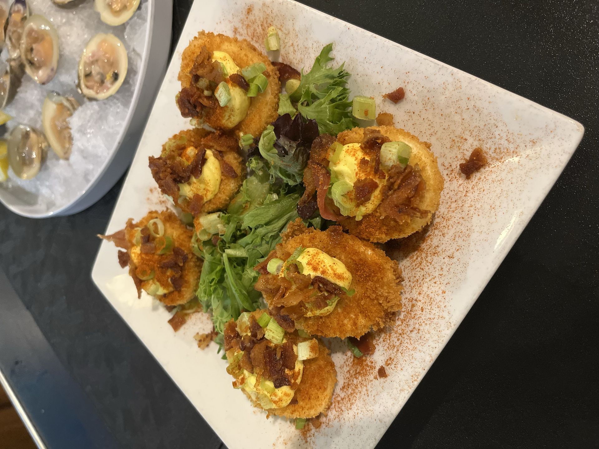 Long table set for event, with table number 1, bottles as decor, clear glassware, and large windows.