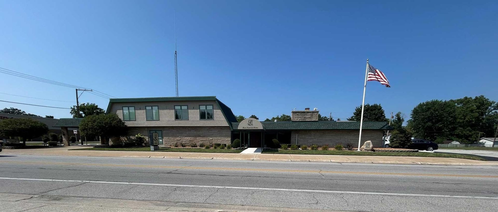 Building with an American flag blowing in the wind on a sunny day.