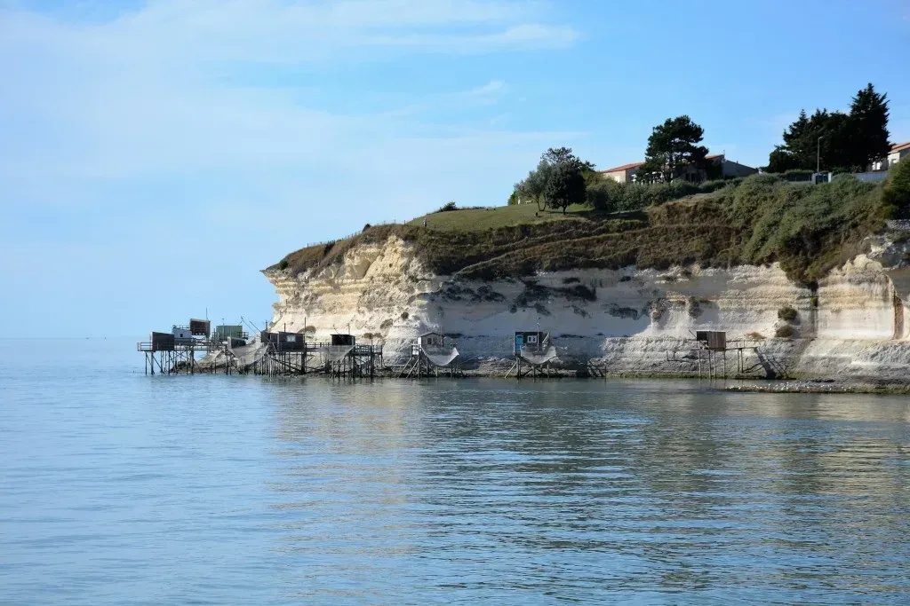 Une grande étendue d'eau avec une falaise en arrière-plan.