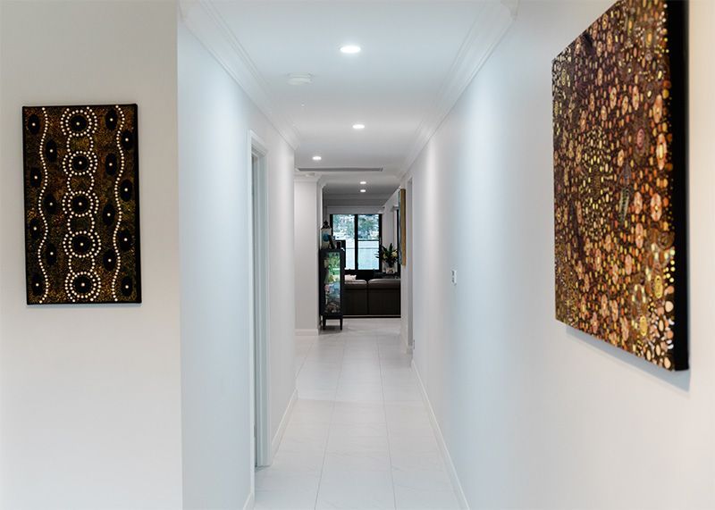 White Tiled Hallway With Indigenous Art on the Walls — Custom Home Builders in the Hunter Valley