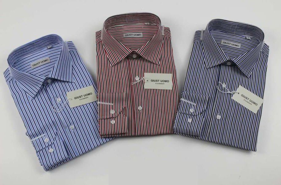 Tre camicie eleganti a righe piegate, nei colori blu, rosso e blu su sfondo bianco.