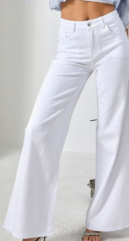 Pantaloni bianchi a gamba larga indossati da una modella su sfondo chiaro.