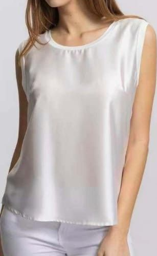 Camicetta bianca senza maniche in raso abbinata a pantaloni bianchi, mostrata corta dalle spalle ai fianchi.