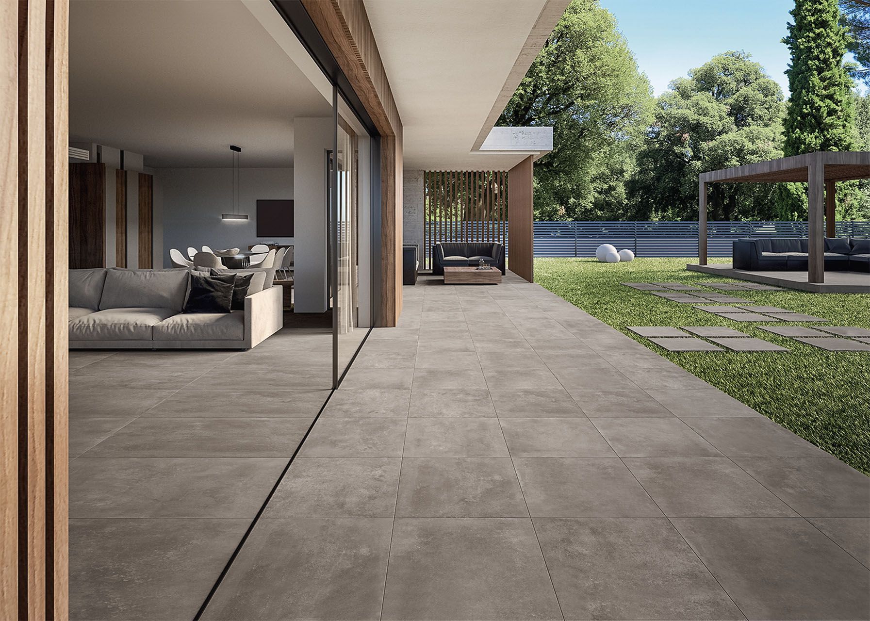 Ein Wohnzimmer mit gefliesten Boden einer Couch und einer Glasschiebetür zu einer gefliesten Terrasse.