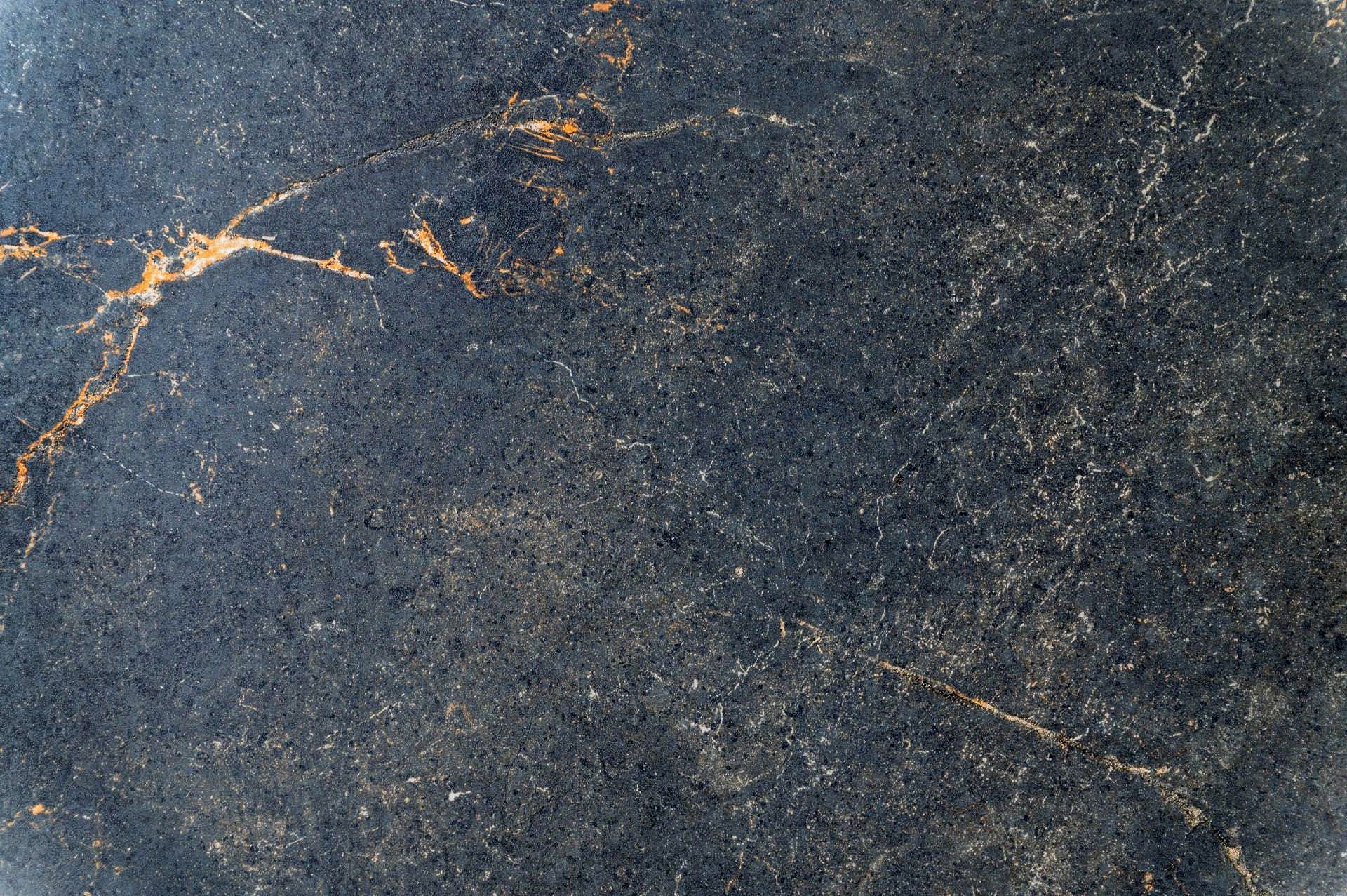 Eine Nahaufnahme einer schwarz-goldenen Marmorstruktur.